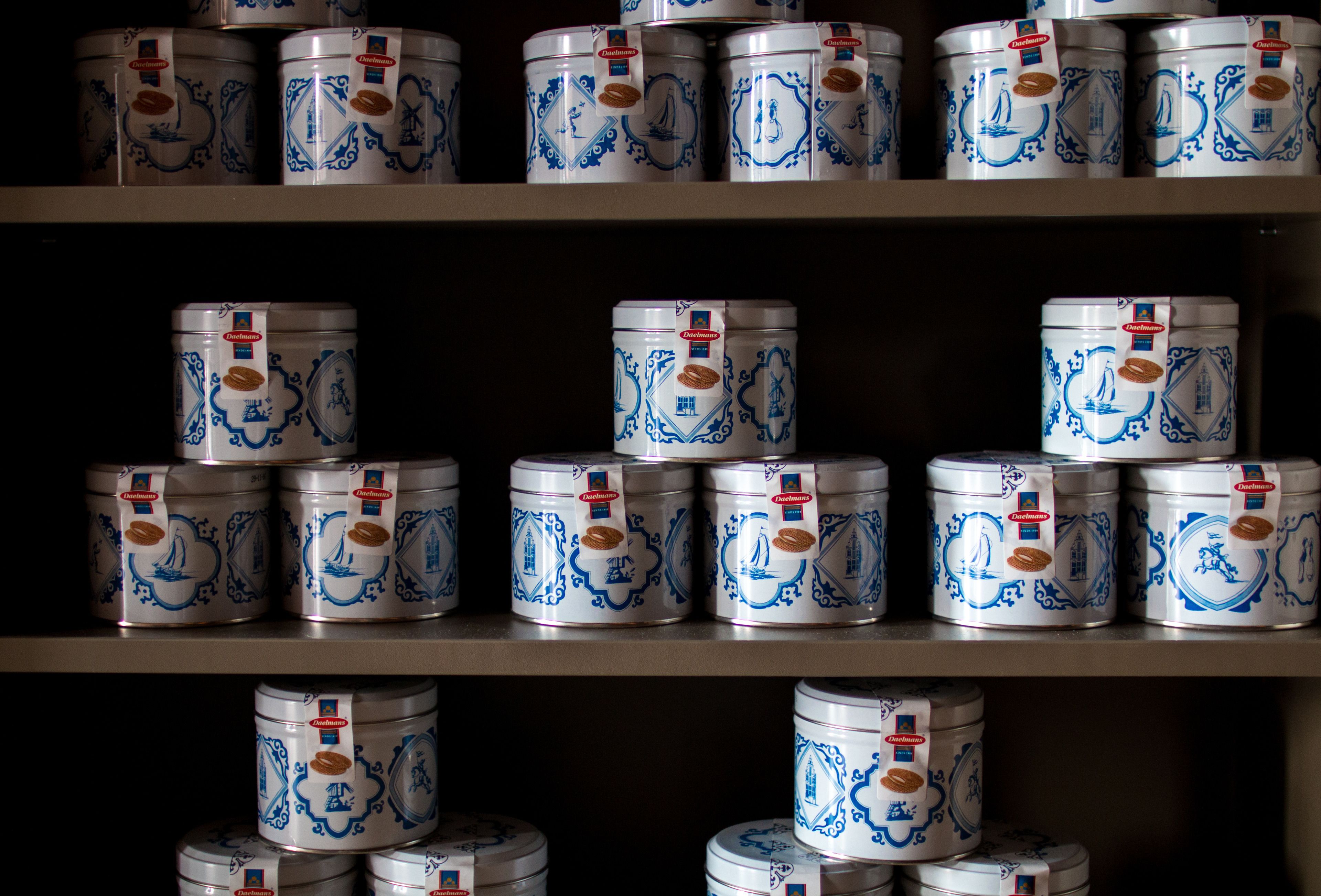 Varias estanterías con filas de recipientes blancos y azules con diseño.