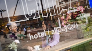 Interior de un hotel con una recepción, una taza de café en la encimera y un arreglo floral.