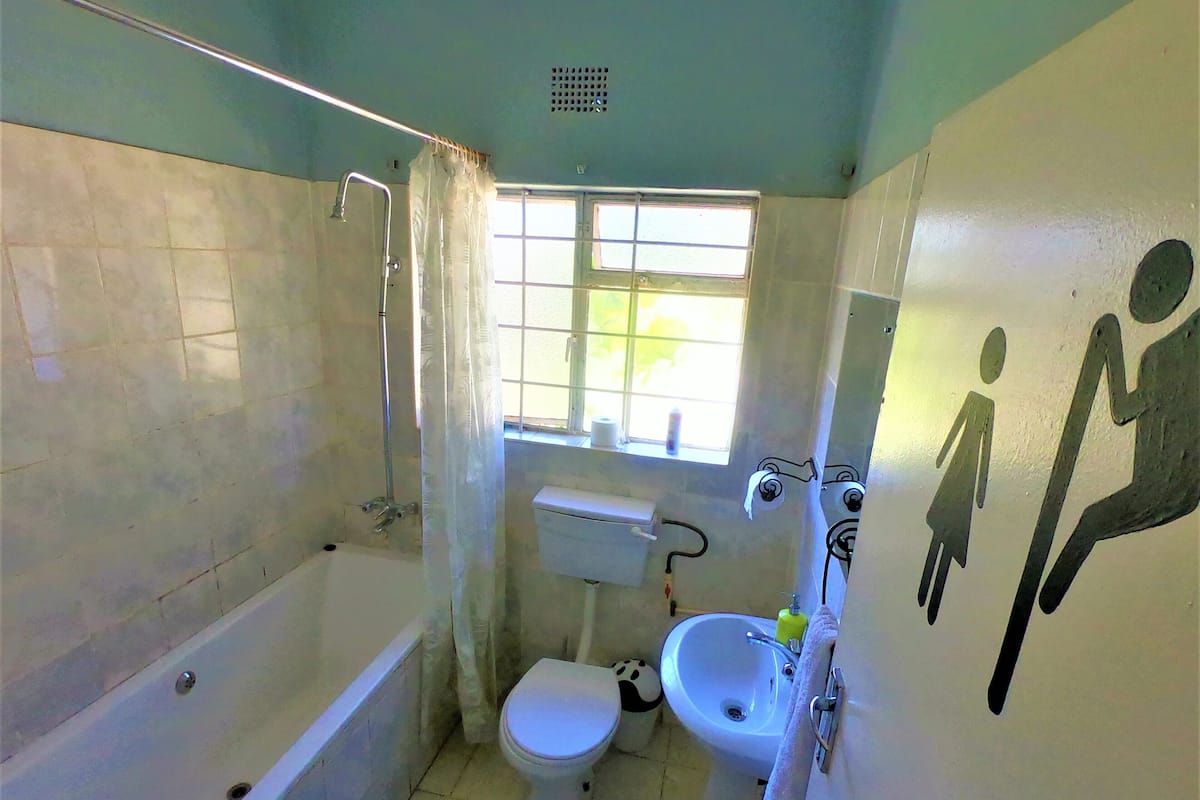 Une petite salle de bain compacte, équipée d’une baignoire, de toilettes et d’un lavabo.
