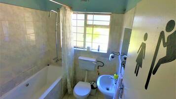 Un baño pequeño y funcional con bañera, inodoro y lavabo.