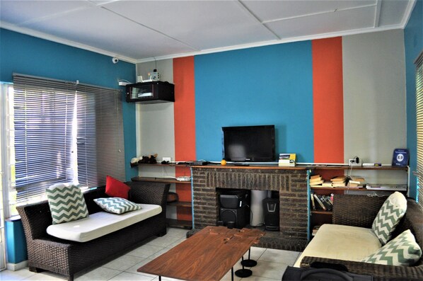 A living room with a sofa, a coffee table, a television, and a fireplace.