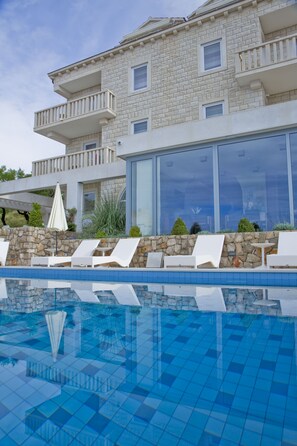 Piscine extérieure, parasols de plage, chaises longues