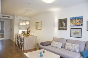 Ein modernes Wohnzimmer mit einer Couch, einem Couchtisch und einem Essbereich mit Stühlen und einem Tisch.