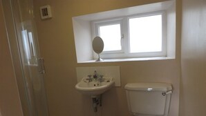A bathroom with a toilet, sink, and a window above the sink. - Hillis Close Farm (Haltwhistle)