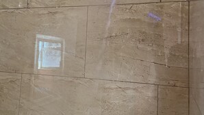 A showerhead with water flowing down a tiled wall. - Delux Inn Clearwater (Clearwater)