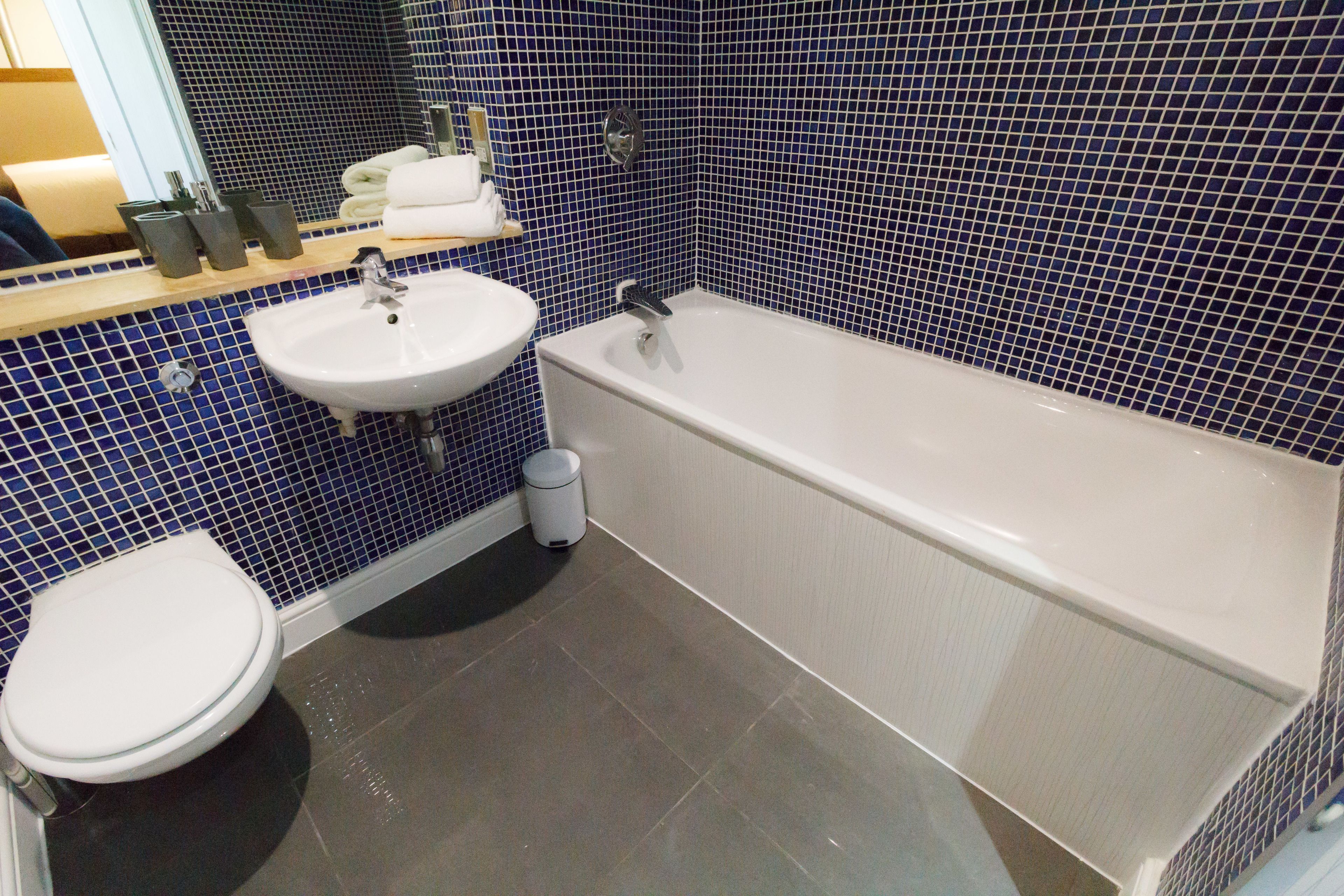 Et badeværelse med en hvid vask, badekar og toilet.