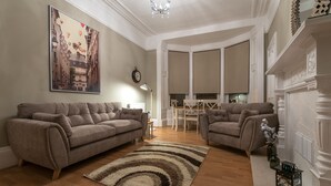 Ein Wohnzimmer mit zwei Sofas, einem Teppich und einem Kamin.