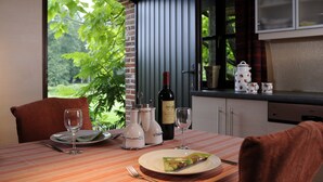 A dining table set with wine glasses, a bottle of wine, and a plate of food. - 't Vijverhof (Geraardsbergen)