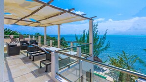 A balcony with a view of the sea, furnished with chairs and tables. - Villa Encantada by Coco B Isla (Isla Mujeres)
