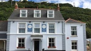 A two-story building with a sign for 'The Postworth Arms' bar and restaurant. - Portreath Arms (Redruth)