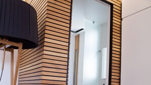 A modern bathroom with a wooden slatted wall design, a white toilet, and a mirror. - Sea View High End Rooftop Triplex (Tel Aviv)