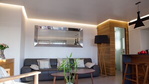 A modern living room with a sofa, coffee table, and a large mirror. - Sea View High End Rooftop Triplex (Tel Aviv)