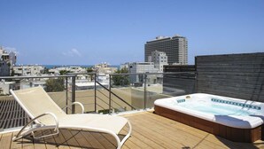 A rooftop terrace with a hot tub, a lounge chair, and a city view. - Sea View High End Rooftop Triplex (Tel Aviv)