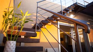 A staircase leading to an upper floor, a potted plant, and a building exterior. - Sea View High End Rooftop Triplex (Tel Aviv)