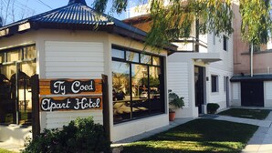 Un pequeño edificio de una sola planta con un letrero que dice "Ty Coed Apart Hotel".