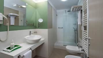 Une salle de bain moderne équipée d’un lavabo, de toilettes et d’une douche.
