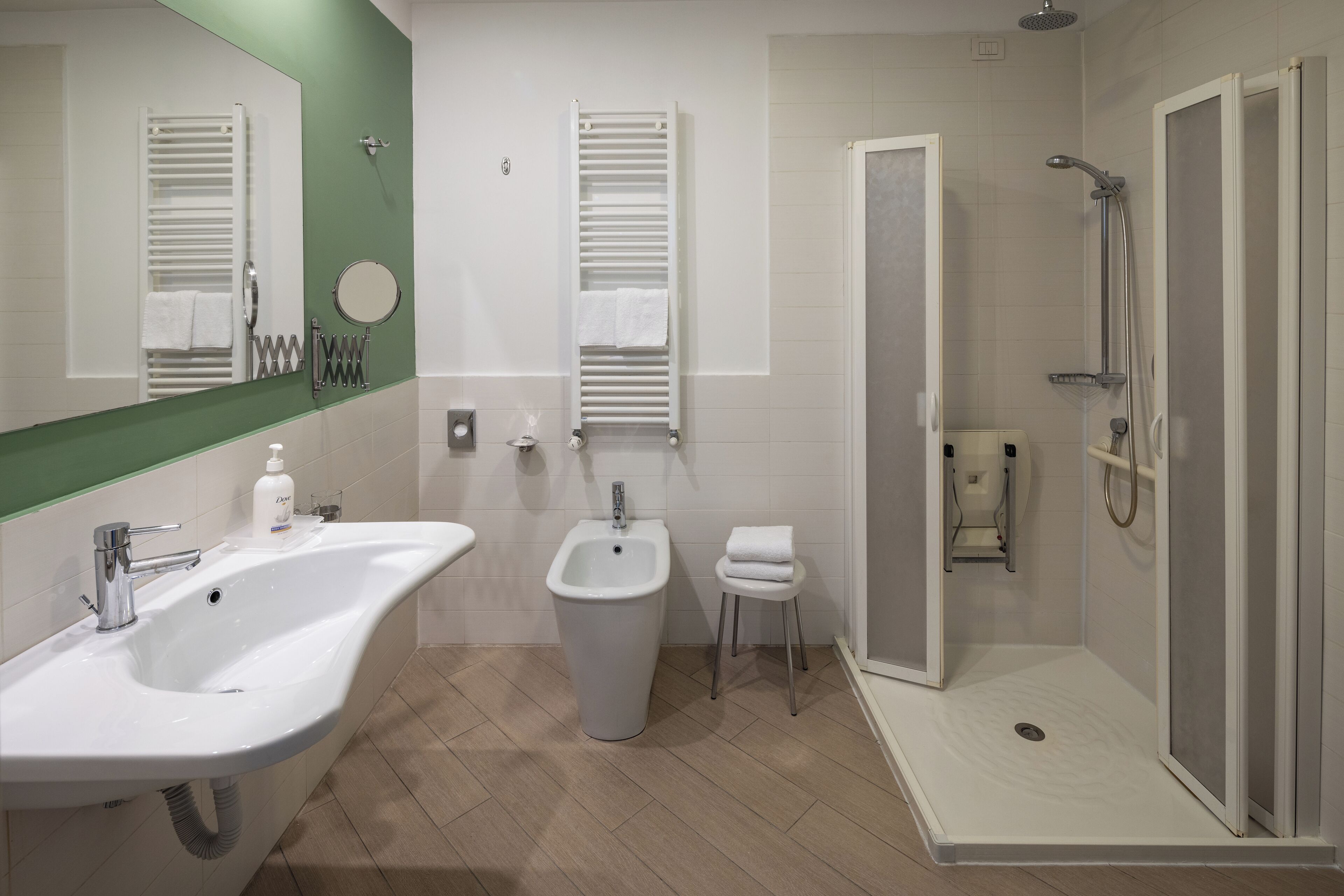 Een moderne badkamer met een groot wastafel, toilet met douchefunctie en ruime douche.