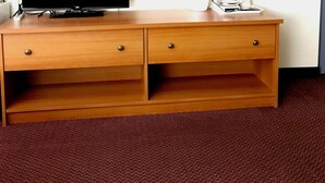 Un bureau en bois, un téléviseur à écran plat, un miroir et une machine à café.