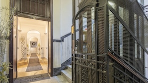 A hotel entrance with a metal gate, a carpeted entrance, and a staircase leading to the upper floors. - Residenza Castrense (Rome)