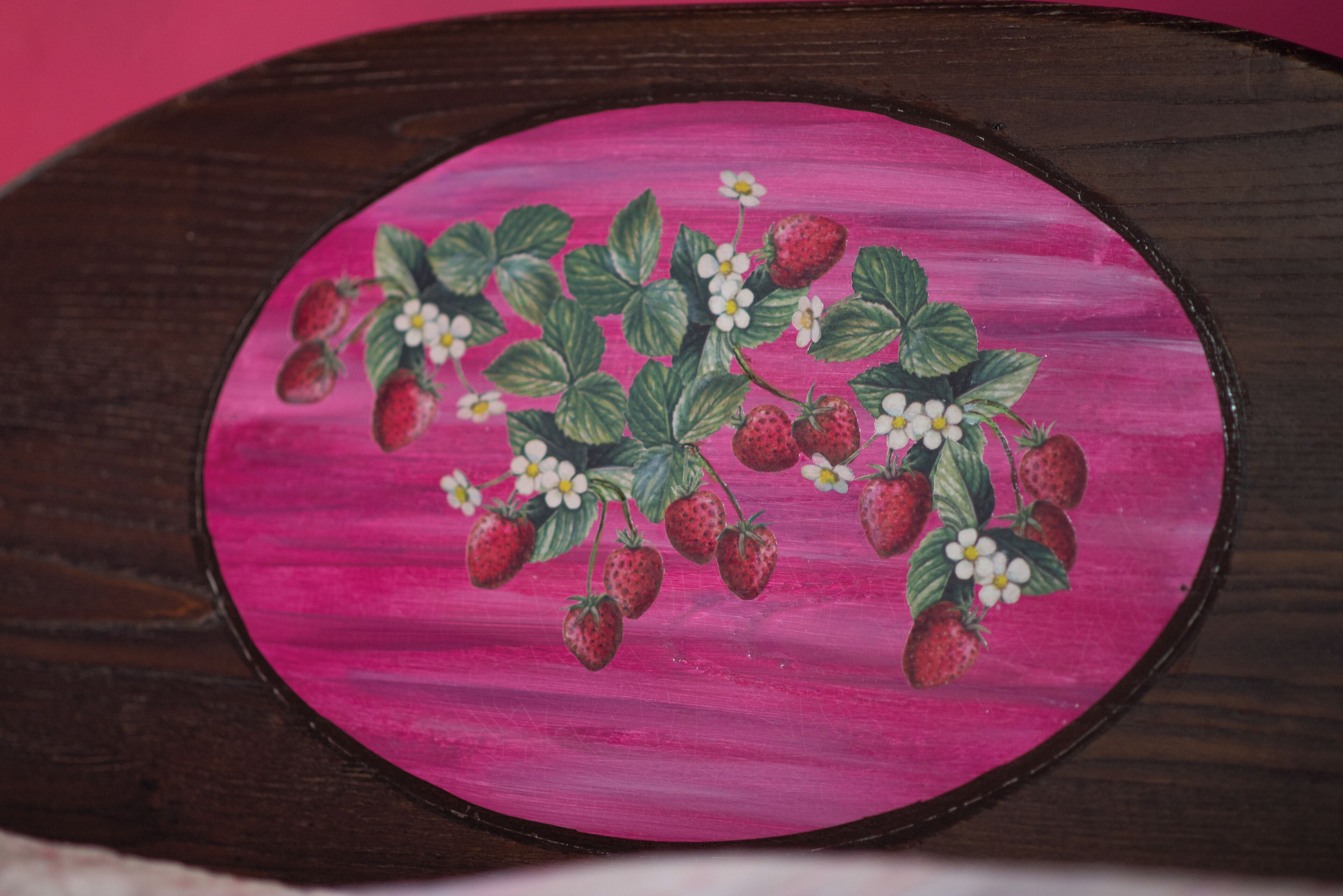 A wooden plaque with a pink background and a strawberry branch illustration.
