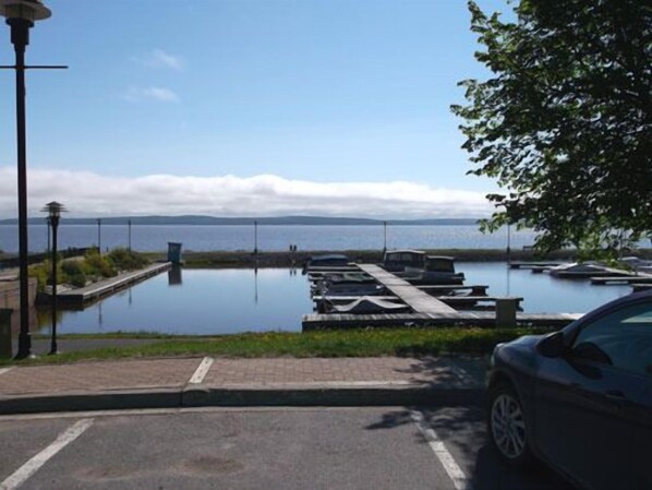 A marina with boats docked, a clear sky, and a distant view of land. - Haileybury Beach Motel (Temiskaming Shores)
