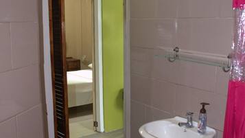 A bathroom with a sink, mirror, and a shower curtain.