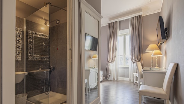 A modern bathroom with a glass-enclosed shower, a sink, and a vanity. - Suite Castrense (Rome)