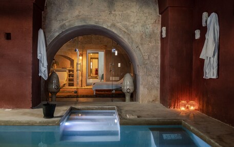 A spa area with a pool, a massage chair, and a sauna.