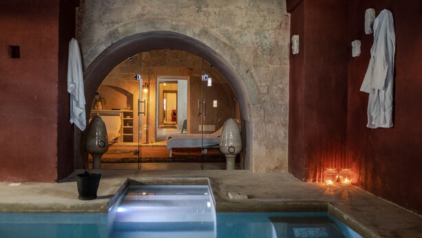 Uma área de spa com piscina, cadeira de massagem e sauna.