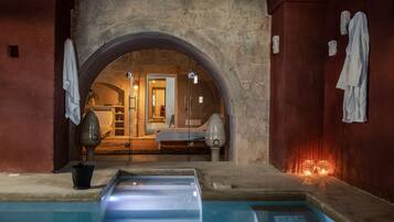 Relax in a serene spa area with a tranquil pool and adjacent massage room.