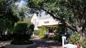 A pathway leading to a house with a garden and a pergola. - Jonquil Cottage (Franschhoek)