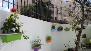 A balcony with potted plants and a tree. - Curitiba Casa Hostel (Curitiba)