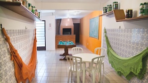 A dining area with a pool table, chairs, and a brick fireplace. - Curitiba Casa Hostel (Curitiba)