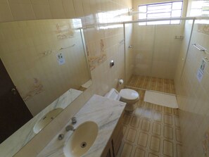 A bathroom with a toilet, sink, and shower area. - Curitiba Casa Hostel (Curitiba)