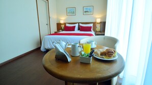 Habitación de hotel con cama, una mesa de comedor y alimentos para el desayuno, y vista del cuarto.