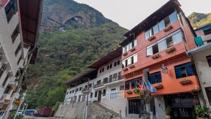 A building with multiple floors, balconies, and a staircase leading to the upper levels. - Nativus Hostel Machu Picchu (Machu Picchu)