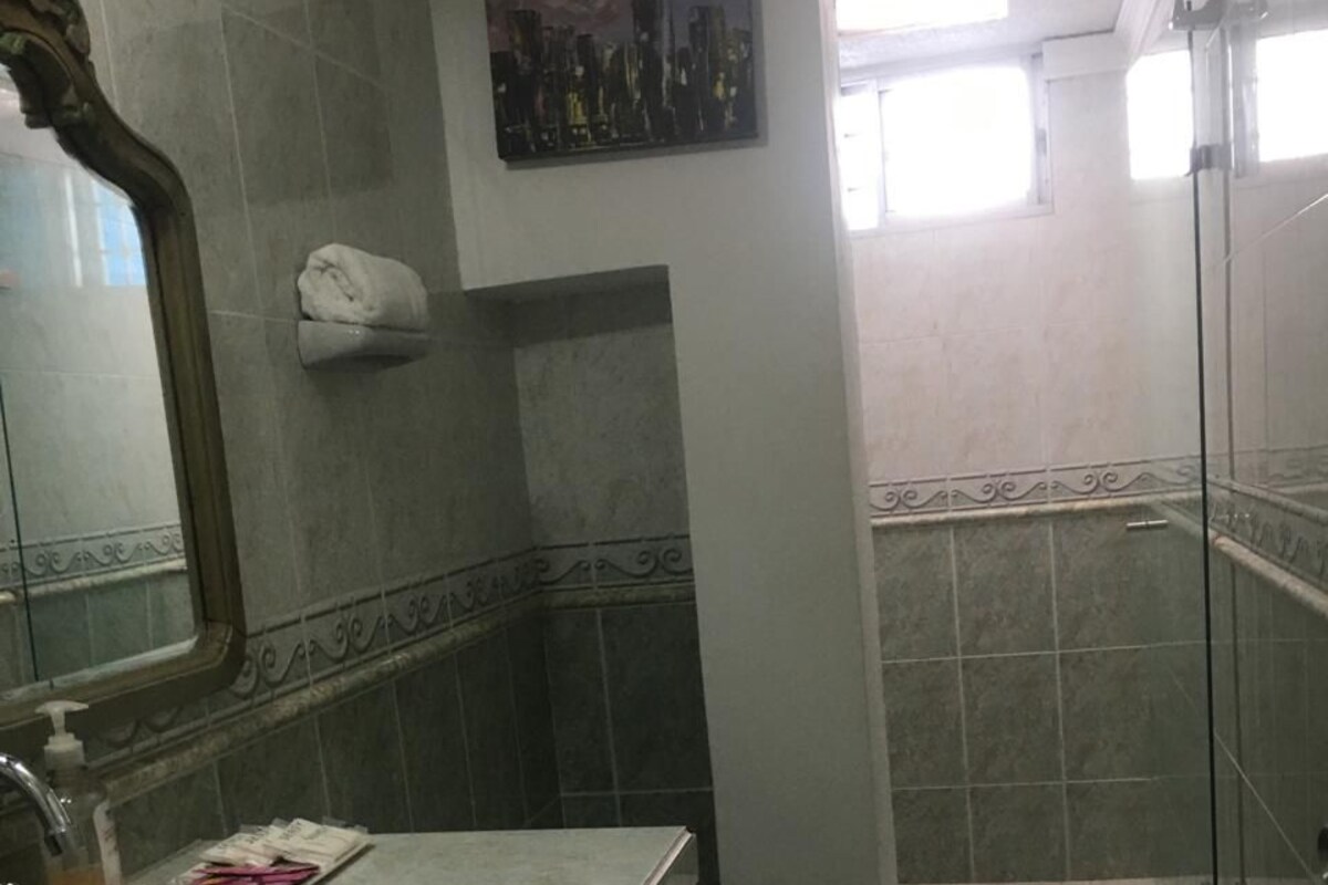Une salle de bain équipée d’un lavabo, d’un miroir, de toilettes et d’un espace douche.