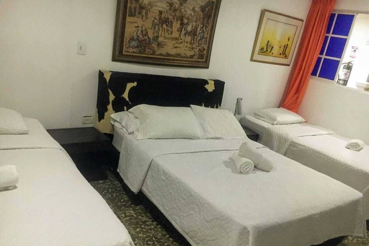Una habitación de hotel con una cama, una mesita y una silla.