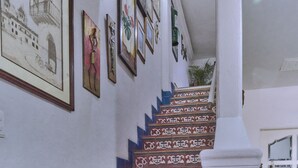 Un escalier avec des marches décoratives et des œuvres d’art encadrées accrochées aux murs.