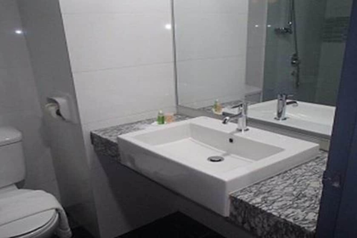 Une salle de bain avec des toilettes, un lavabo et un miroir.