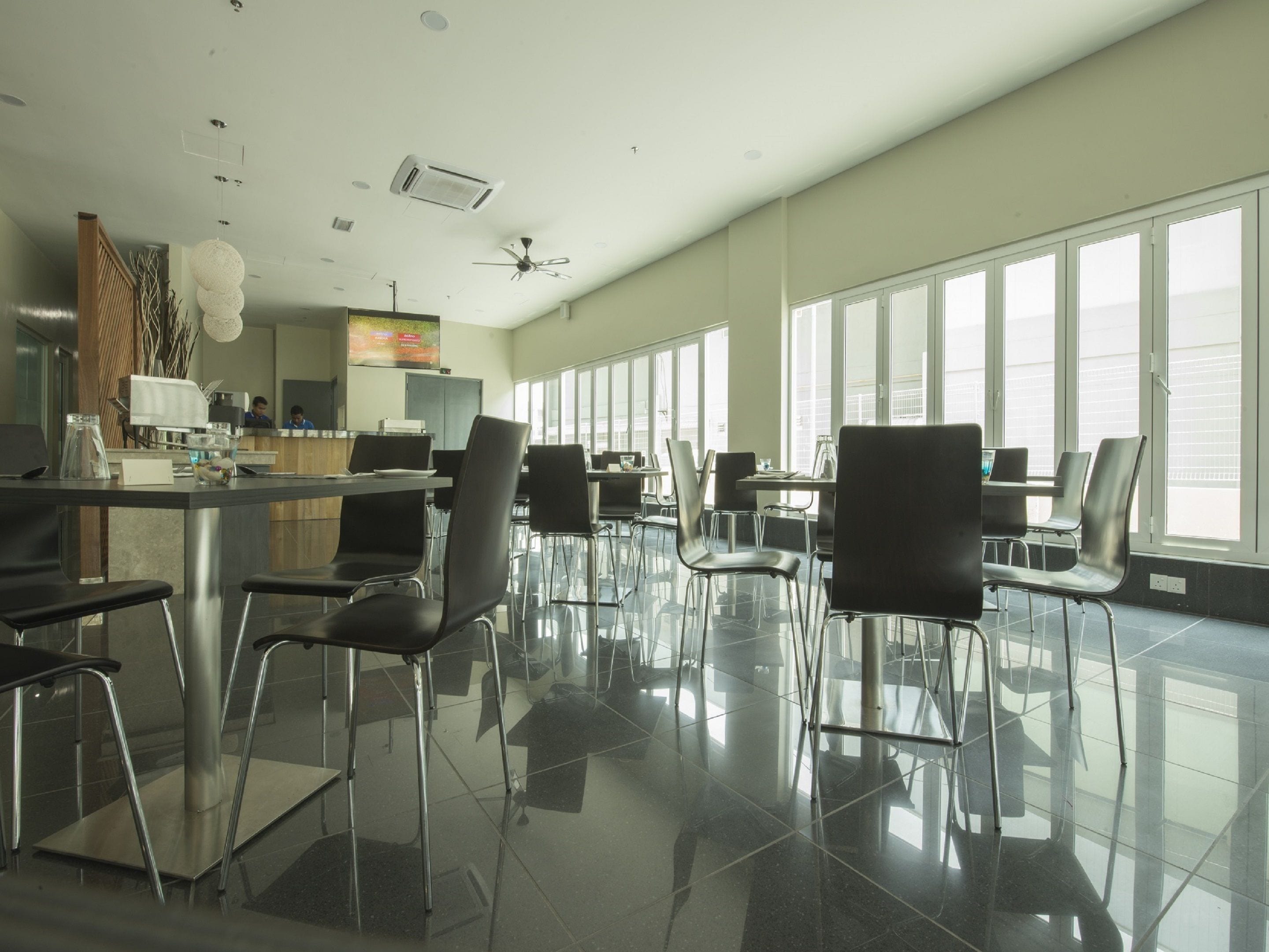 Un restaurant spacieux et moderne, doté de hauts plafonds, de grandes fenêtres et d’un intérieur épuré et minimaliste.