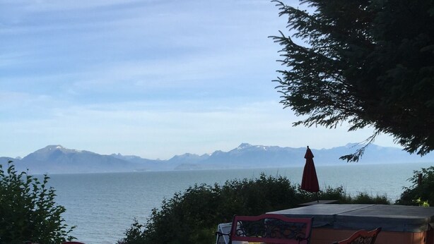 Une terrasse extérieure offrant une vue sur la mer et les montagnes.