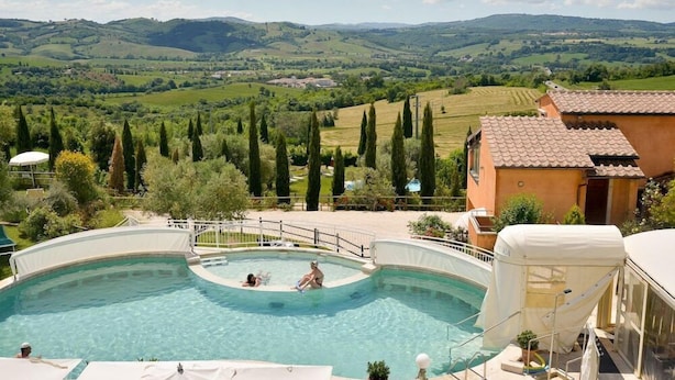 A swimming pool with a view of rolling hills and vineyards.