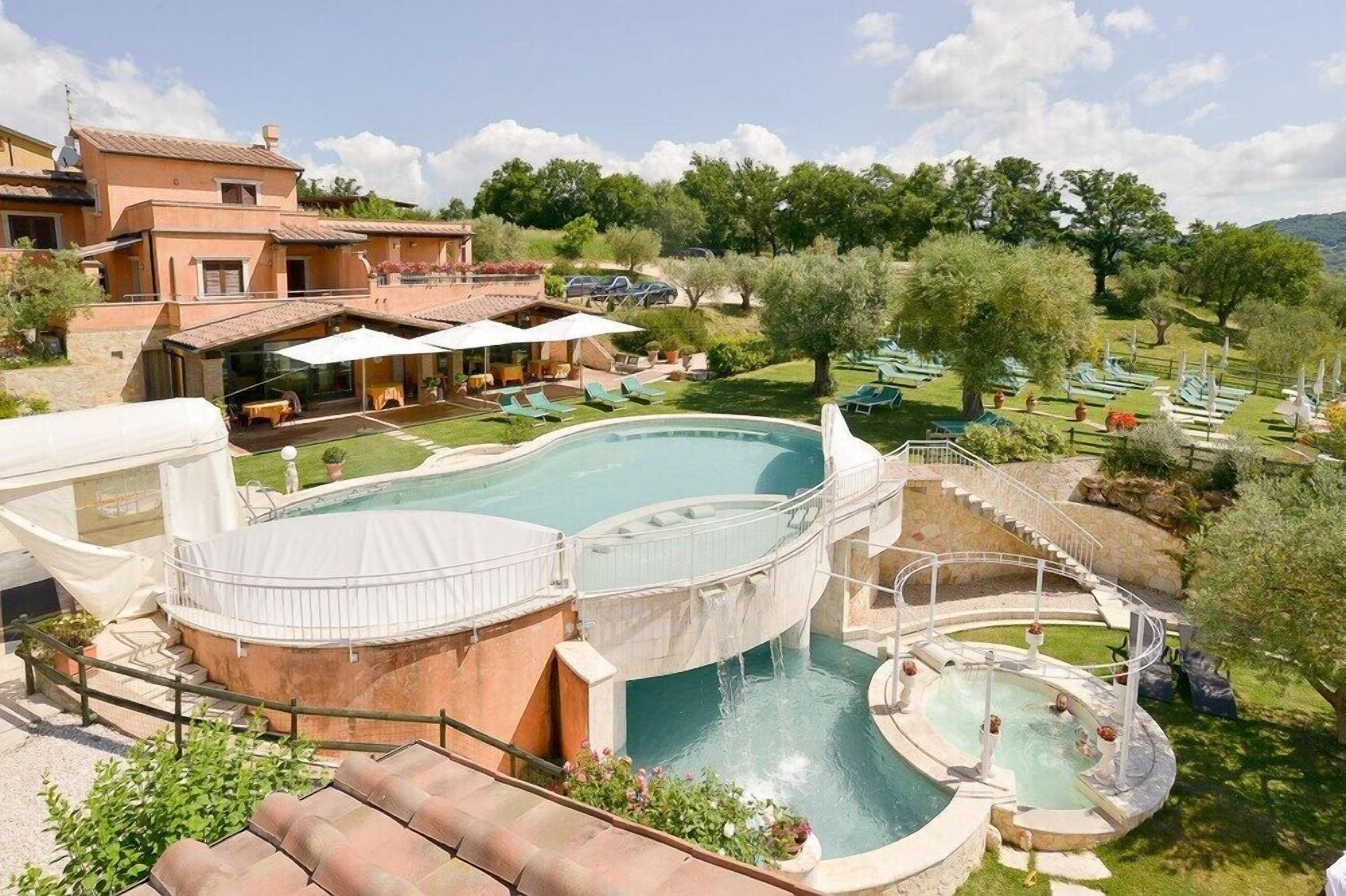 Ein Resort mit großem Pool, Sitzgelegenheiten im Freien und einem schönen Ausblick auf die umliegende Landschaft.