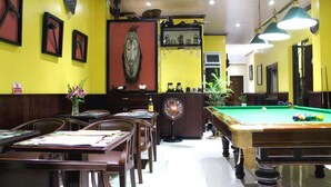 A billiards room with a pool table, chairs, and a bar area. - Murray Guesthouse (Chau Doc)