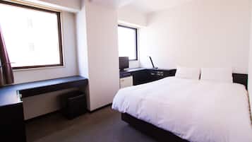 Um quarto com cama, escrivaninha e janela.