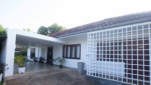 Uma casa moderna com varanda coberta, plantas em vasos e telhado telhado.