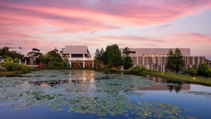 A modern building with a reflective water pond in front. - The Annex (Seogwipo)