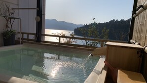 A hot tub with a view of a lake and mountains. - Hotel Musashiya (Hakone)