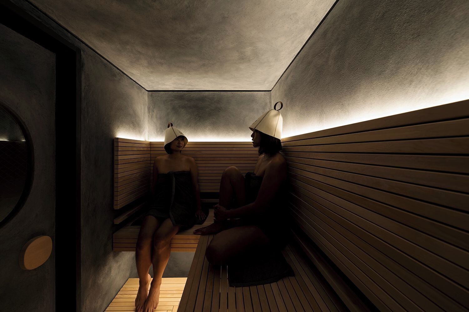 A sauna with wooden benches and a circular door.